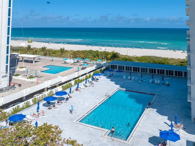 birds eye view of property featuring a water view and a beach view