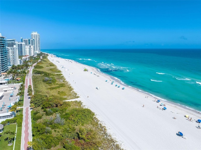 aerial view featuring a view of city, a water view, and a beach view