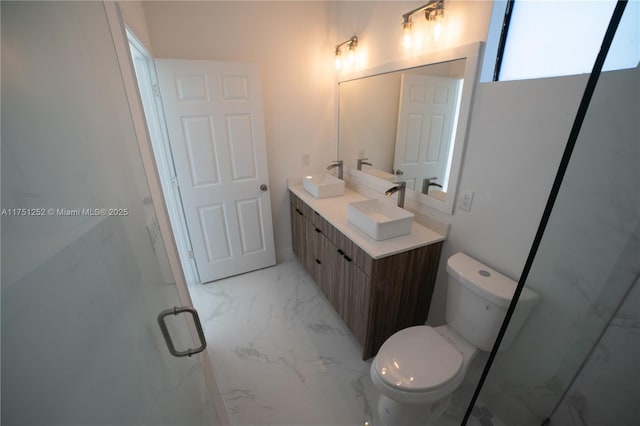 bathroom featuring marble finish floor, a sink, a shower stall, and double vanity