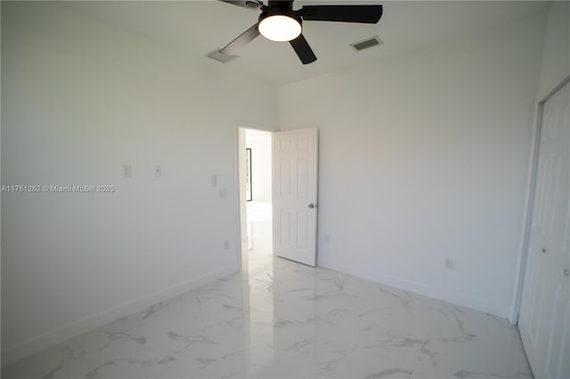 unfurnished room featuring marble finish floor, baseboards, visible vents, and ceiling fan