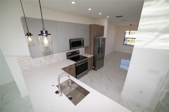 kitchen with marble finish floor, light countertops, appliances with stainless steel finishes, and modern cabinets