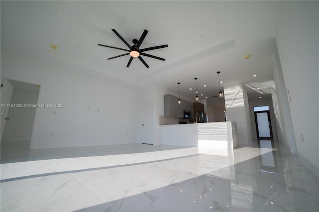 empty room with a ceiling fan, recessed lighting, a raised ceiling, and marble finish floor