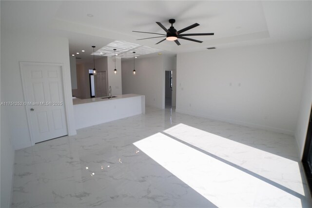 spare room with a sink, visible vents, a ceiling fan, marble finish floor, and a tray ceiling