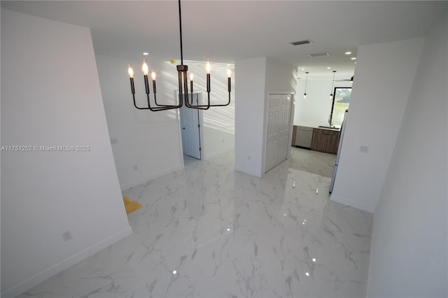 unfurnished dining area featuring a chandelier, marble finish floor, visible vents, and baseboards