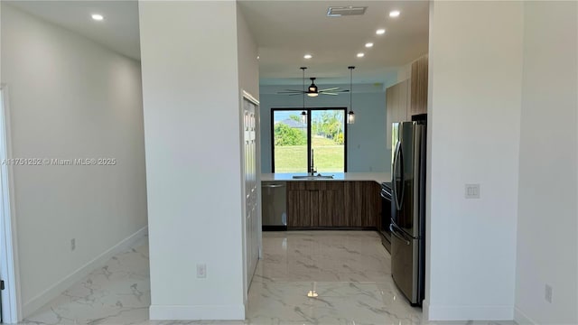 kitchen featuring baseboards, marble finish floor, light countertops, freestanding refrigerator, and modern cabinets