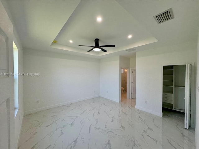 unfurnished bedroom with marble finish floor, recessed lighting, a raised ceiling, visible vents, and baseboards