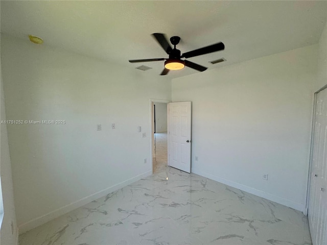 unfurnished bedroom with marble finish floor, baseboards, visible vents, and a ceiling fan