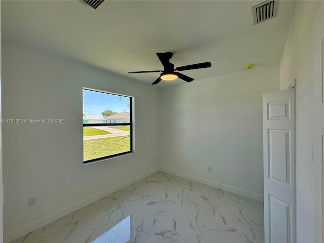 unfurnished room with marble finish floor, visible vents, and baseboards