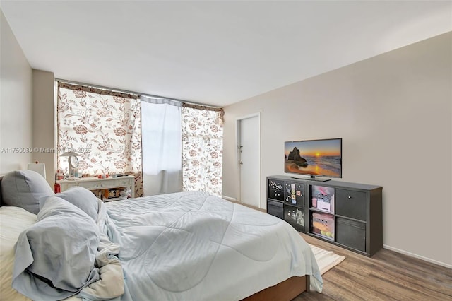 bedroom with baseboards and wood finished floors