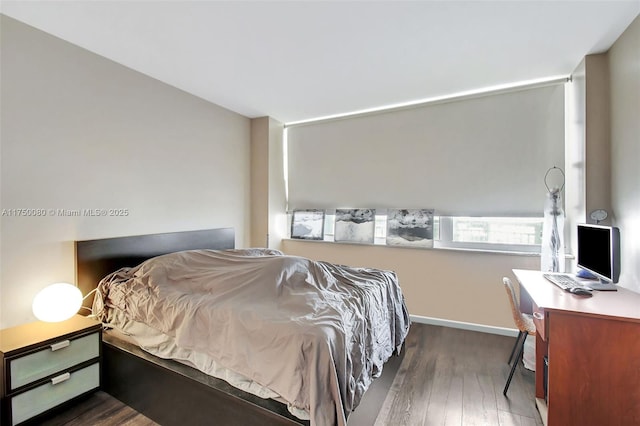 bedroom with baseboards and dark wood-style flooring