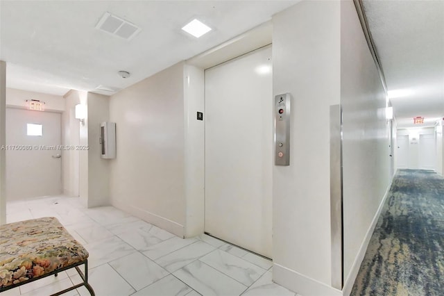 hallway with marble finish floor, baseboards, visible vents, and elevator