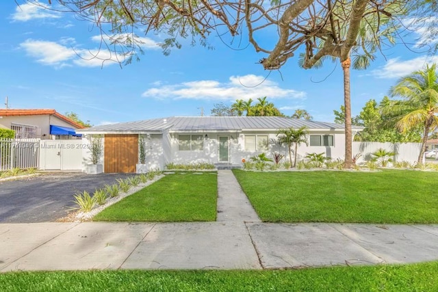 ranch-style house with a gate, fence, metal roof, and a front yard