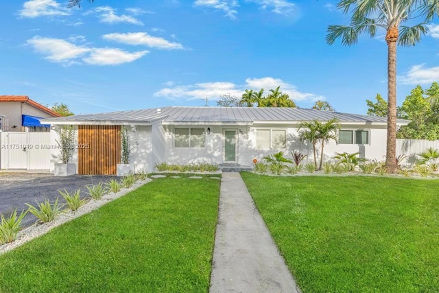 view of front of property featuring fence, a front lawn, and stucco siding