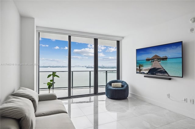 tiled living room featuring a wall of windows and baseboards