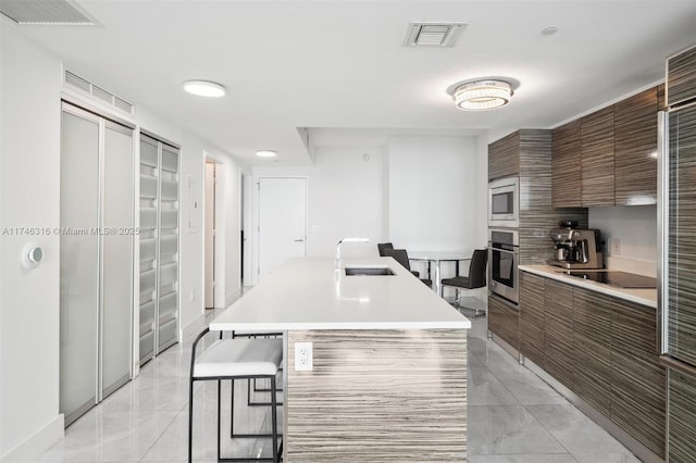 kitchen featuring modern cabinets, stainless steel appliances, visible vents, and light countertops