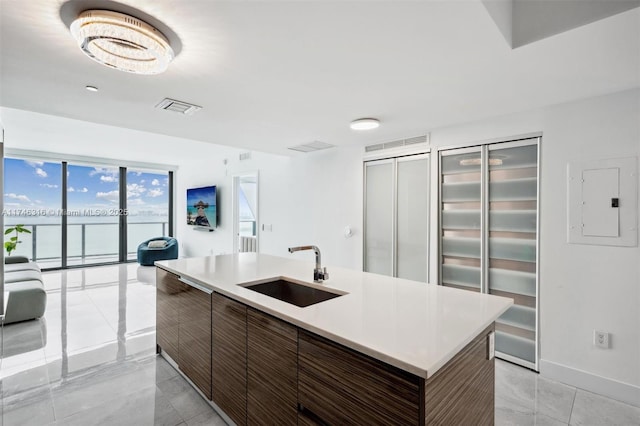 kitchen with visible vents, modern cabinets, a sink, electric panel, and light countertops