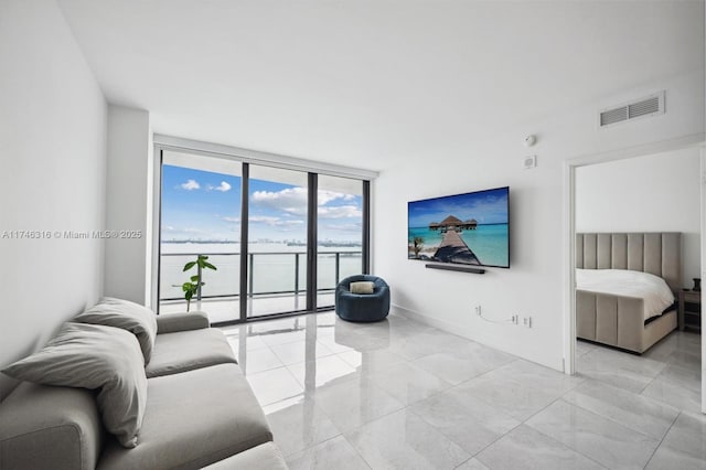 living area featuring visible vents, baseboards, and expansive windows