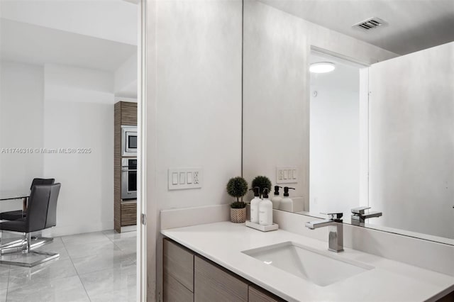 bathroom with vanity, baseboards, and visible vents