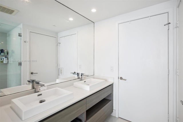 full bathroom with a shower stall, recessed lighting, visible vents, and a sink