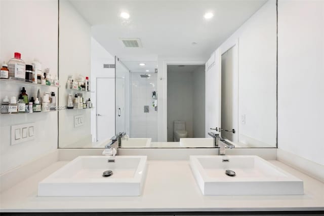 full bath with a sink, toilet, visible vents, and a stall shower