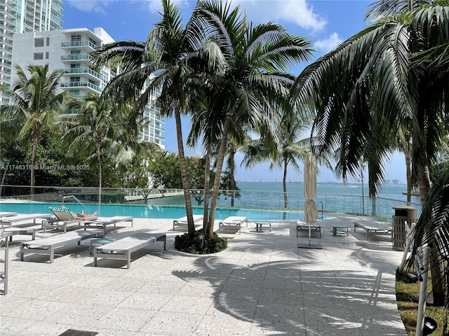 community pool with a patio and a water view