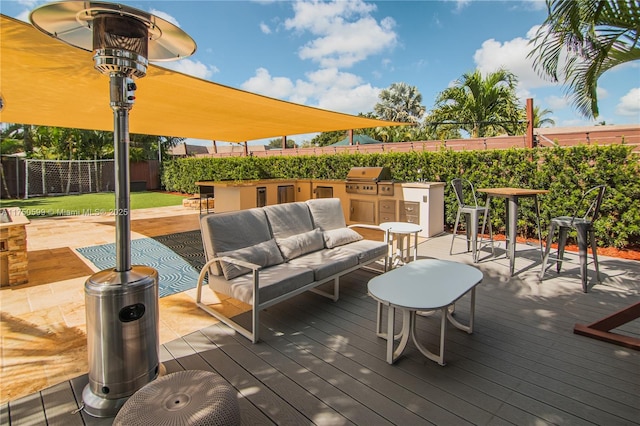 deck featuring an outdoor hangout area, exterior kitchen, a fenced backyard, and a grill