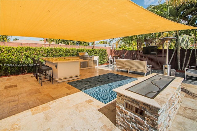 view of patio / terrace with a fenced backyard, exterior bar, area for grilling, and an outdoor hangout area