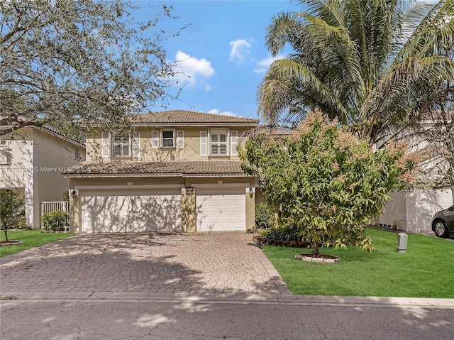 view of front of property with decorative driveway, stucco siding, a garage, a tiled roof, and a front lawn