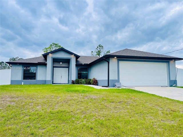 view of front of home with a garage, a front yard, driveway, and stucco siding