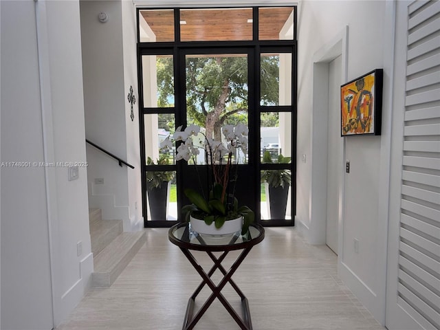 foyer entrance with a wealth of natural light, stairs, and wood finished floors