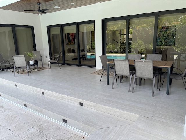 wooden terrace with outdoor dining space and ceiling fan