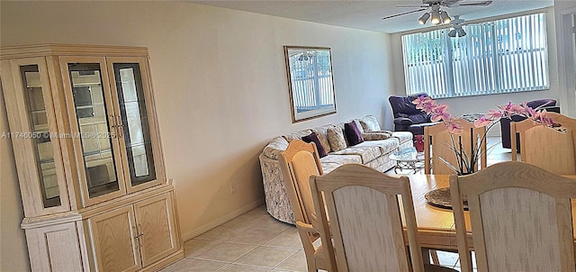 dining area with light tile patterned flooring, a ceiling fan, and baseboards