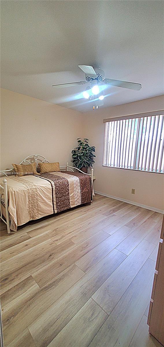 unfurnished bedroom featuring light wood-style floors and a ceiling fan