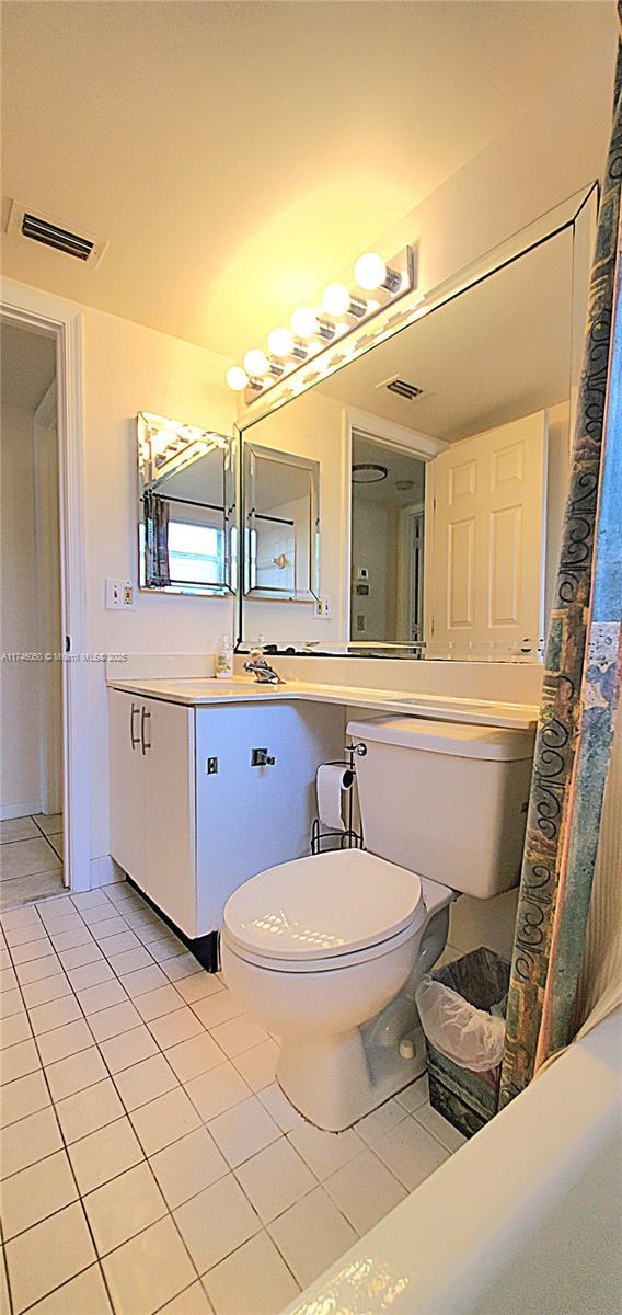 full bath with toilet, vanity, visible vents, and tile patterned floors