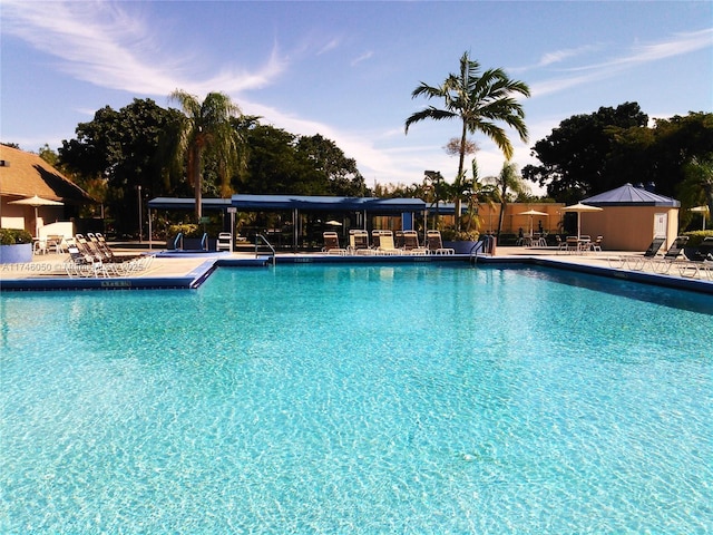 pool at dusk with a patio and a community pool