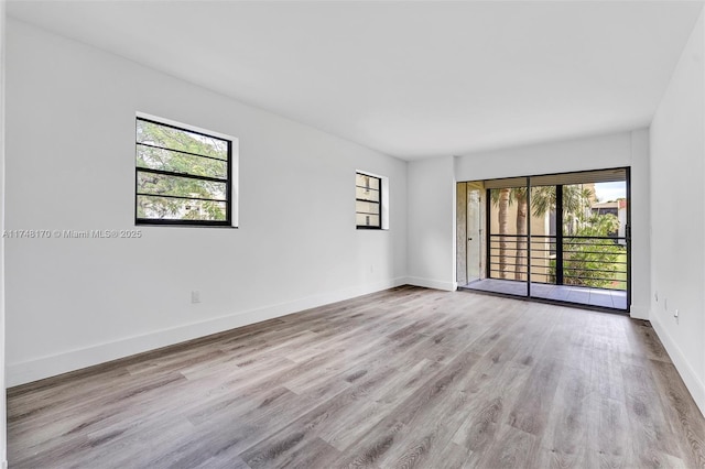 empty room with baseboards and wood finished floors