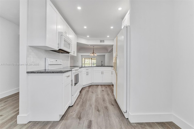 kitchen with white appliances, white cabinets, light wood-style flooring, and decorative backsplash