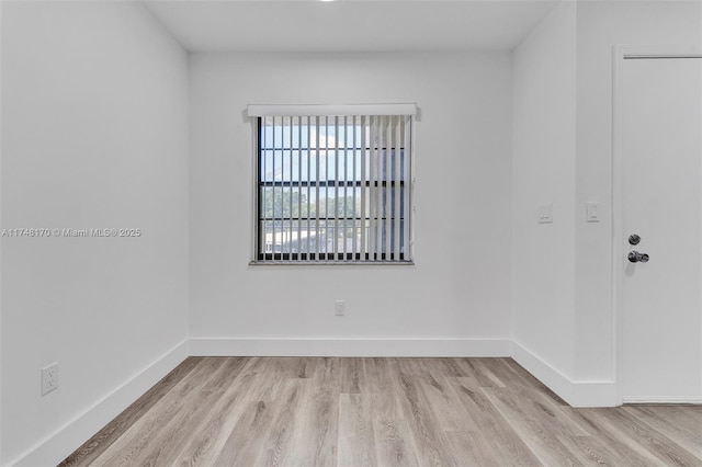 empty room with light wood finished floors and baseboards