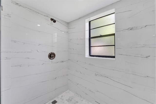 bathroom featuring a marble finish shower