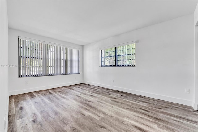 empty room featuring light wood-style flooring and baseboards