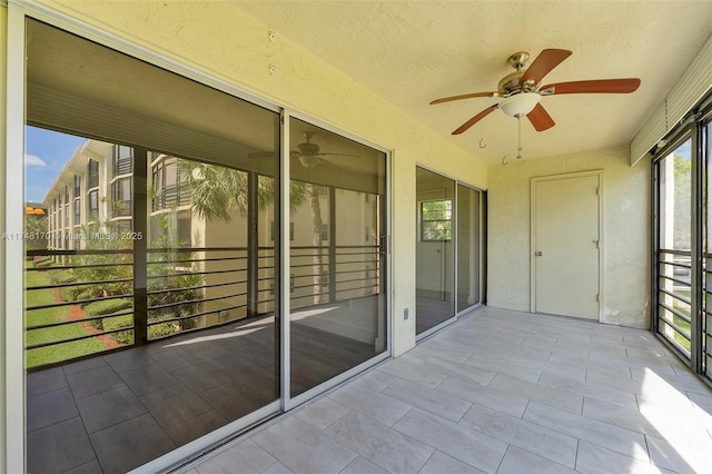 unfurnished sunroom featuring a ceiling fan