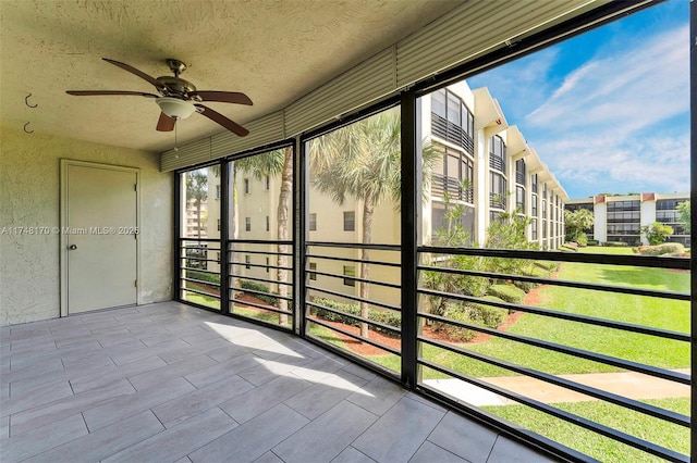 unfurnished sunroom featuring ceiling fan