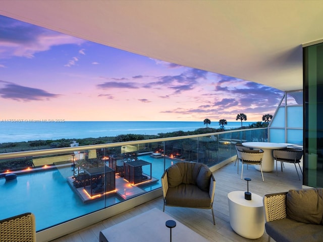 balcony featuring outdoor dining area and a water view