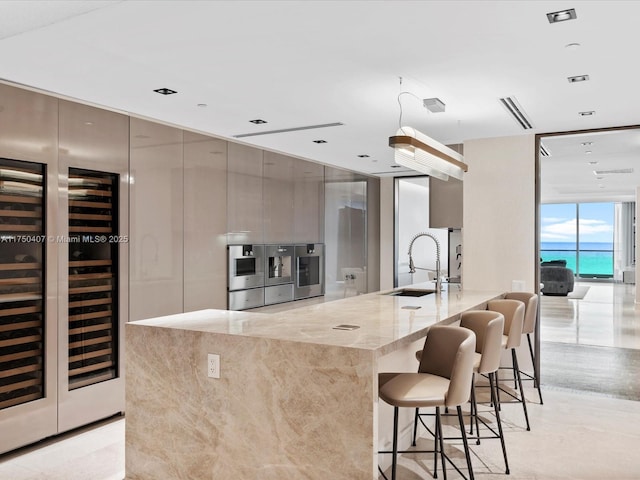 kitchen with modern cabinets, oven, expansive windows, a kitchen bar, and a sink