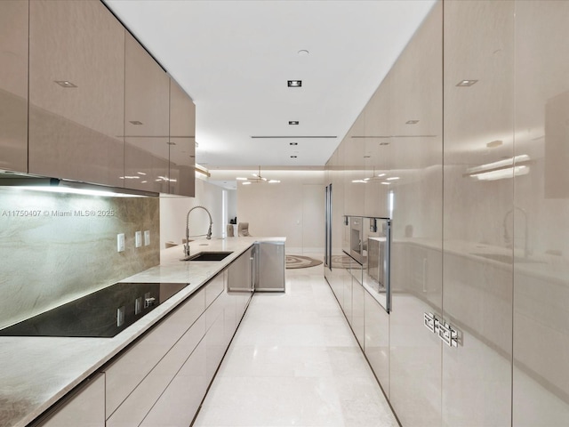 kitchen with tasteful backsplash, light countertops, a sink, modern cabinets, and black electric cooktop