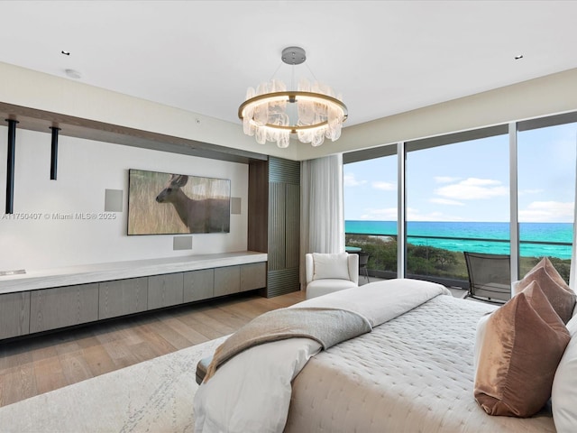 bedroom with light wood finished floors, access to exterior, and a chandelier