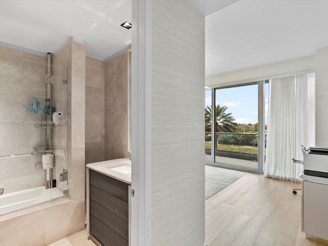 bathroom featuring a combined bath / shower with marble appearance, vanity, and wood finished floors