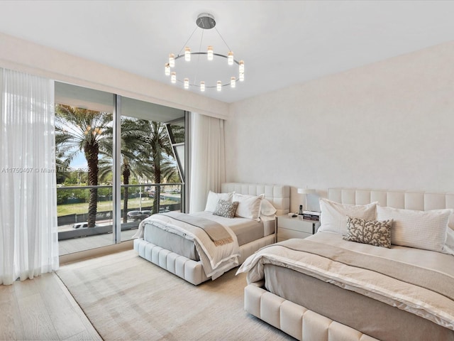 bedroom featuring access to exterior, a chandelier, and light wood finished floors