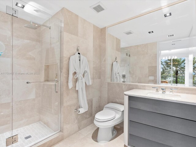 bathroom with toilet, a stall shower, tile walls, and vanity