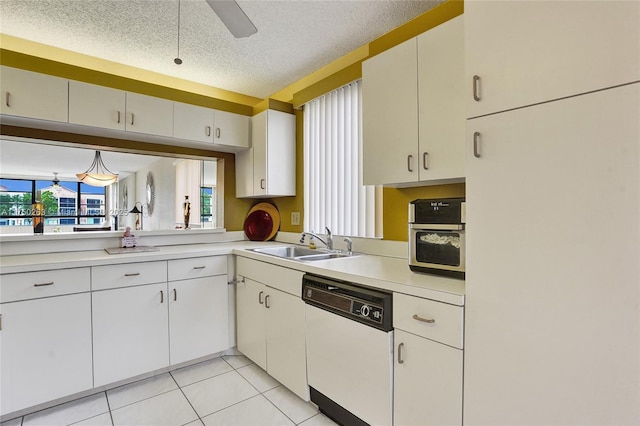 kitchen featuring light tile patterned floors, light countertops, white cabinetry, white dishwasher, and a sink